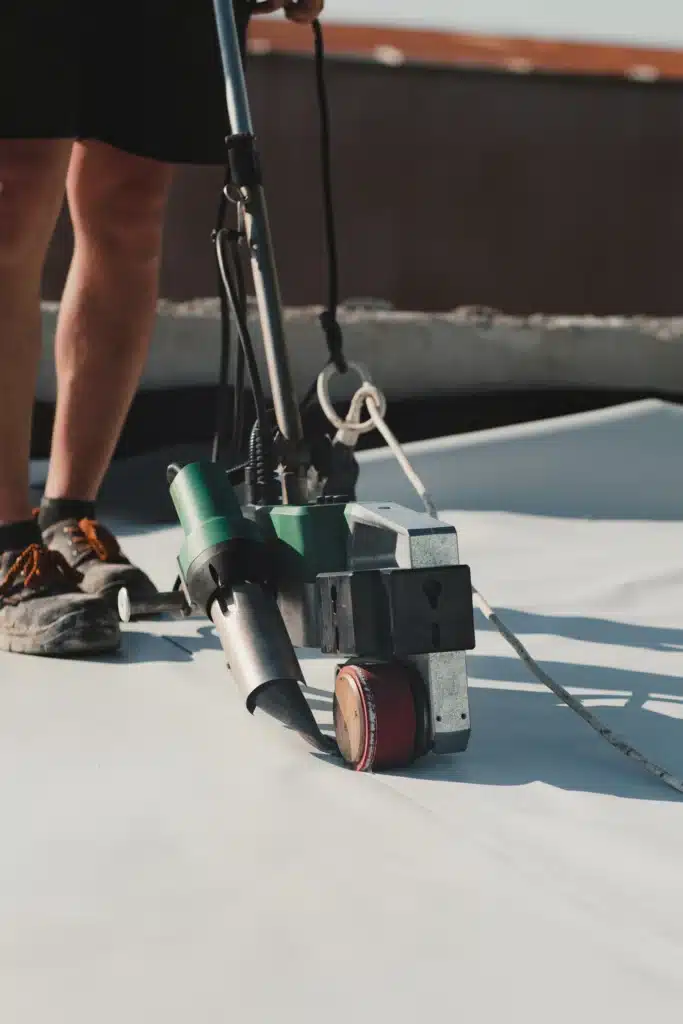 Soudage TPO/PVC : Étanchéité de toiture rapide et efficace. Soudeuse automatique TPO/PVC pour étanchéité de toiture. La machine soude le chevauchement d'une membrane blanche sous la surveillance de l'opérateur.